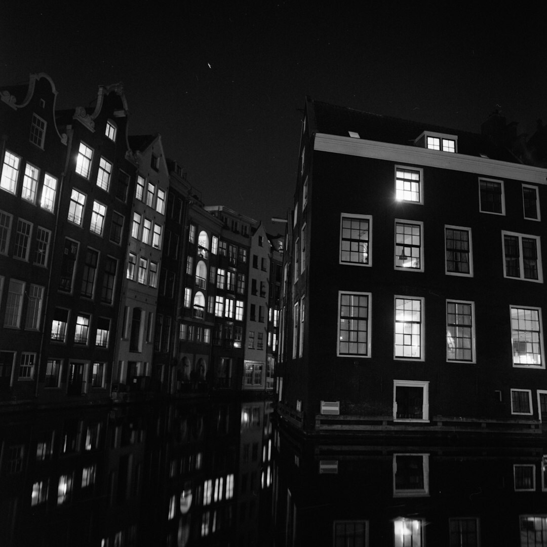 Amsterdam canal houses at night with a single lit window
